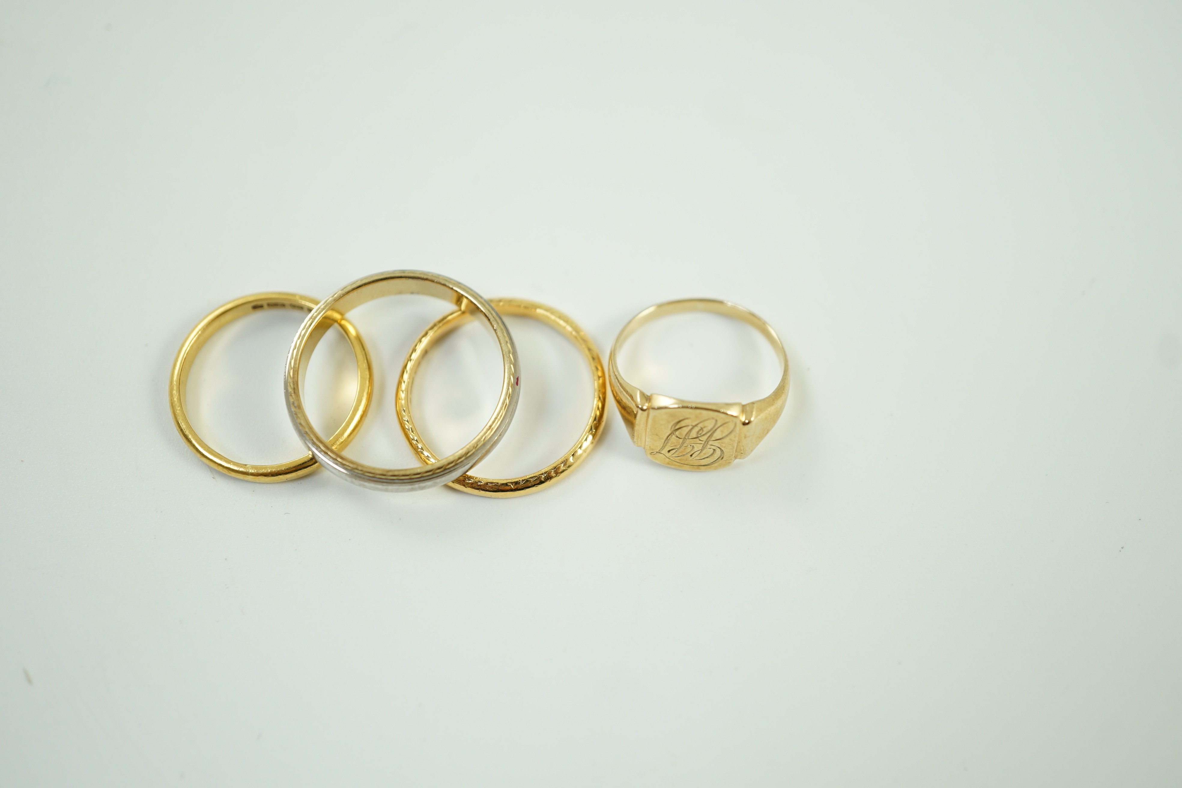 Two 22ct gold wedding bands, 5.2 grams, a 9ct gold signet ring, 2.4 grams and a two colour 750 yellow metal band, 4.4 grams.